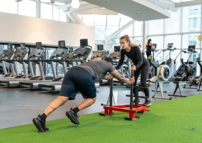 Trainer pushing a sled during a workout.