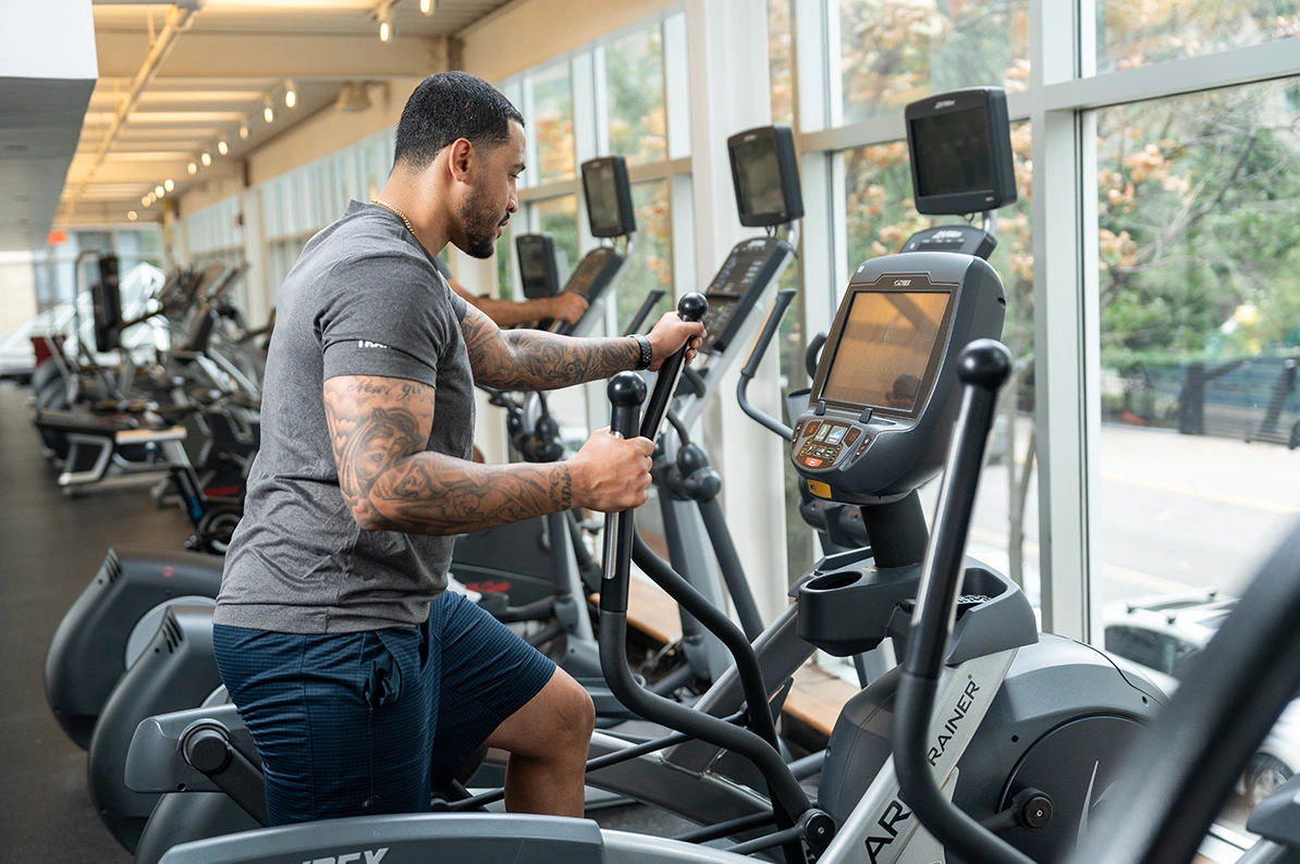 Trainer exercising on an elliptical machine.